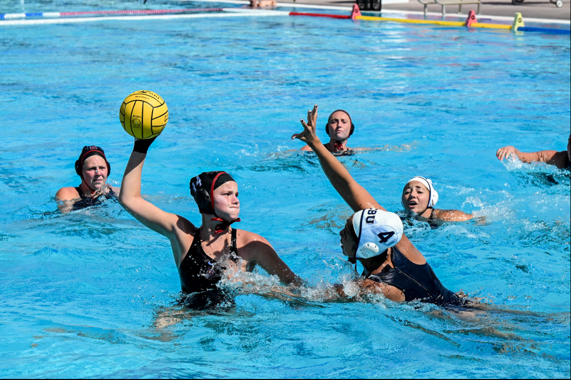 San Diego State attacker Sammi Byers launches a ball while a California Baptist defender attempts to block. Image Courtesy of Golden Coast Conference. 