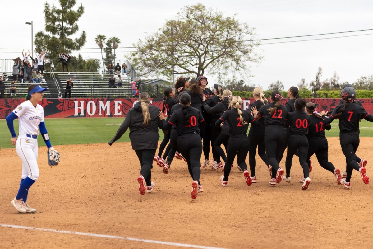 The San Diego State softball team surrounds catcher Cali Decker (11) to celebrate the win against San Jose State on Saturday, May 3, 2025, at SDSU Softball Stadium, Calif.