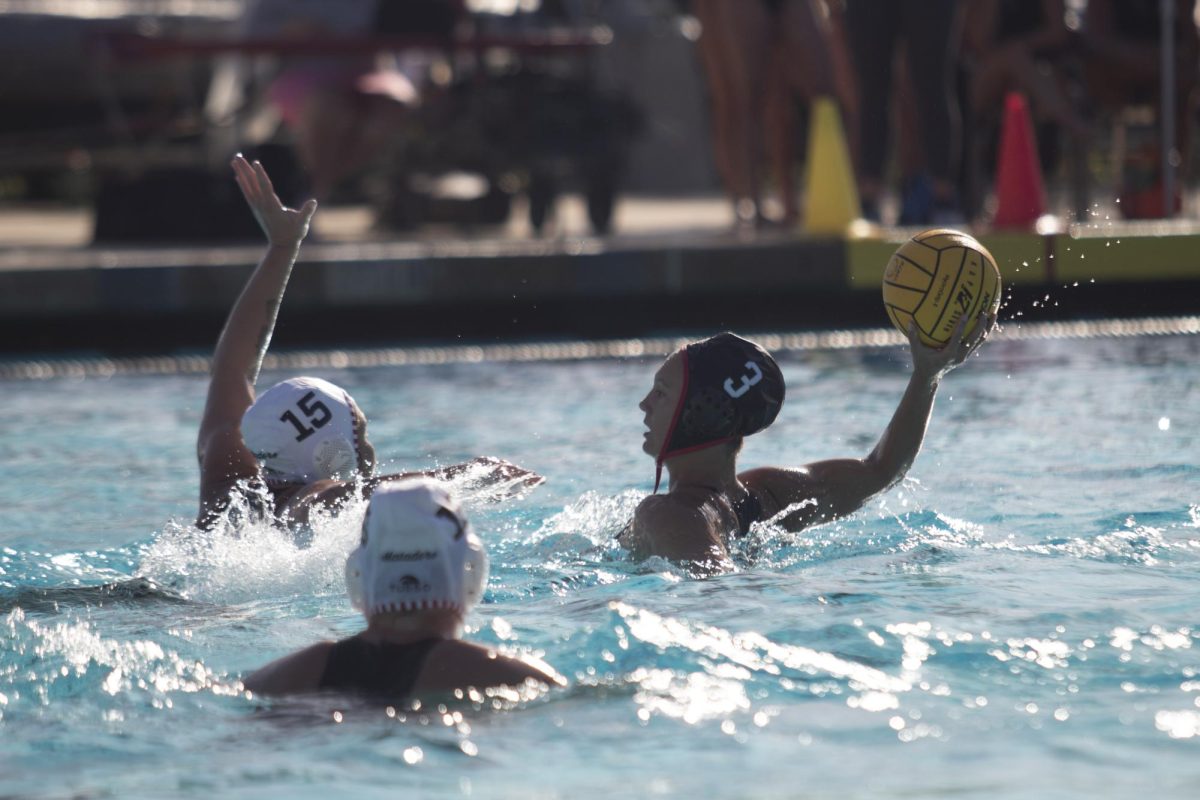 San Diego State attacker Amanda Chambers attempts to thread the ball through two opposing defenders during a game at the Aztec Aquaplex on March 8 2024. 
