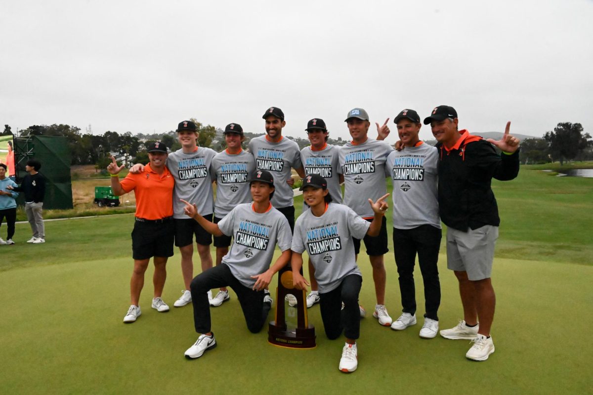 Oklahoma State University players and coaches pose with the NCAA Division I trophy after winning against Virginia.