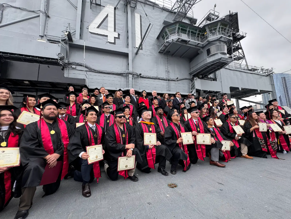 SDSU graduates with military connections pose for a photo at the celebration on the USS Midway in San Diego on Friday, May 2, 2025. 