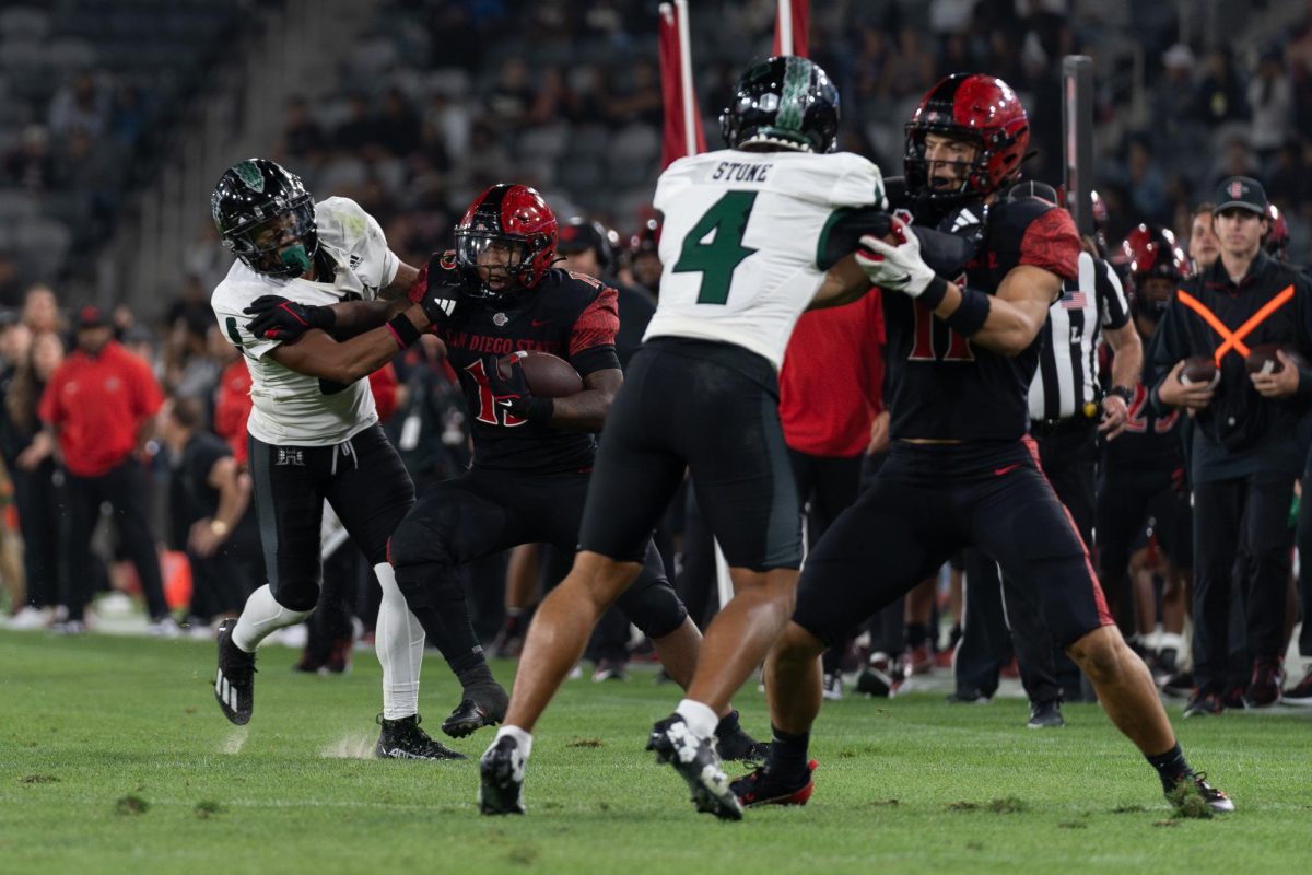  Former San Diego State running back Marquez Cooper attempts to push off a defender while getting a block against Hawaii at SnapDragon Stadium on Saturday October 5, 2024