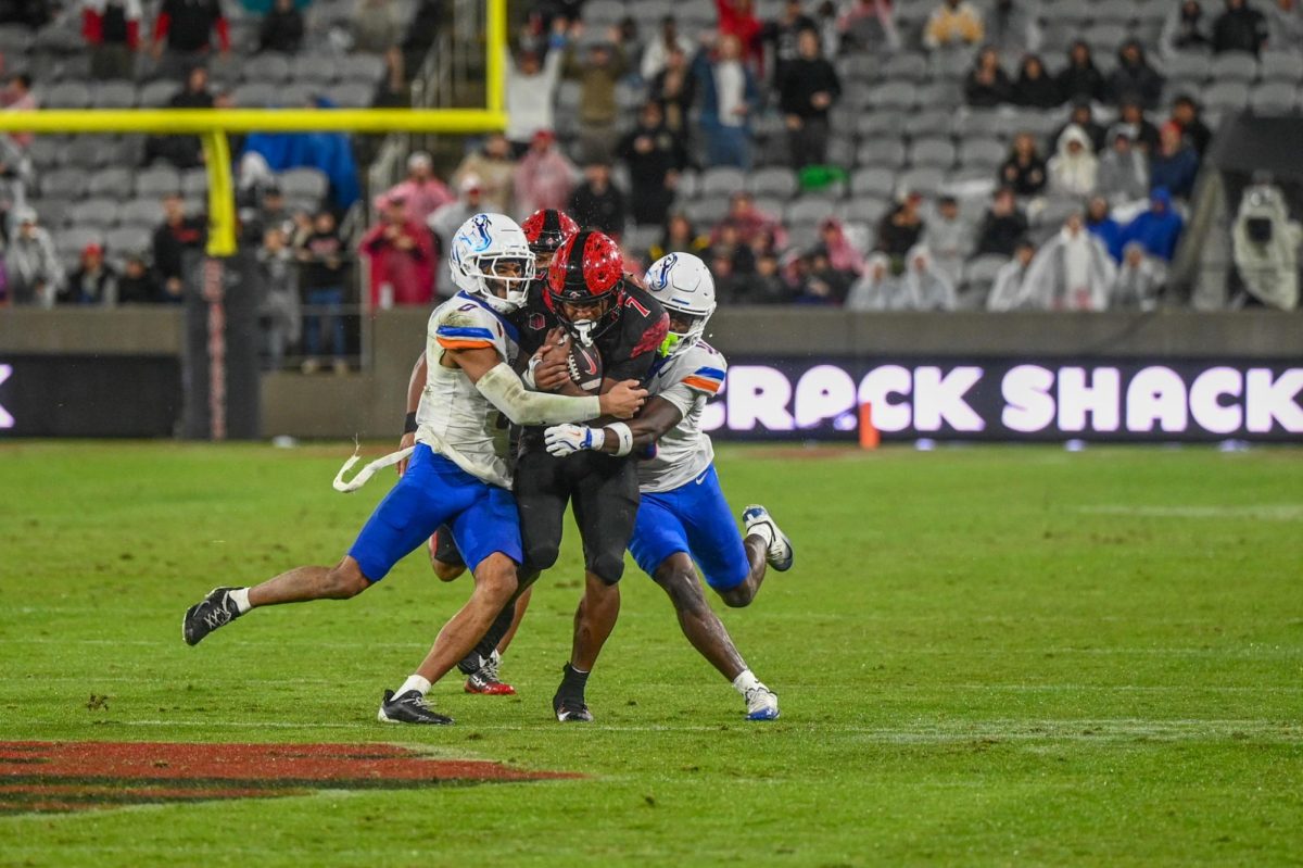 San Diego State running back Lucky Sutton gets brought down by two Boise State defenders at Snapdragon Stadium on Saturday, Nov. 16, 2025.