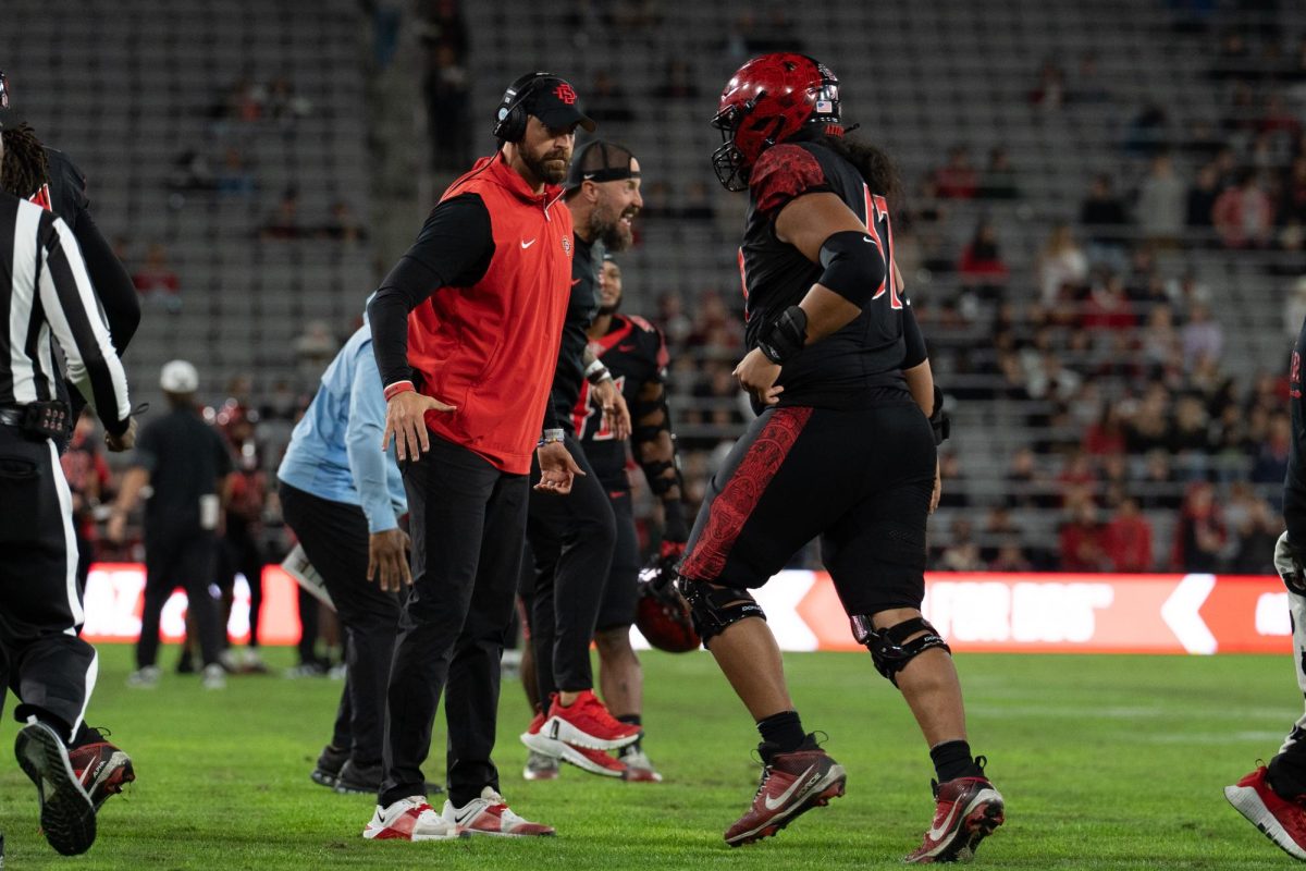 San Diego State head coach Sean Lewis claps up a SDSU football player on Saturday, Nov. 22, 2025, at Snapdragon Stadium.
