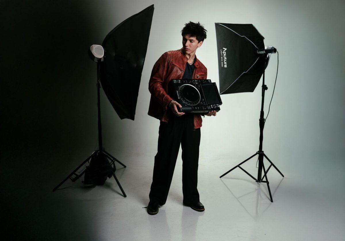 Andre Zelaya holding his DJ equipment