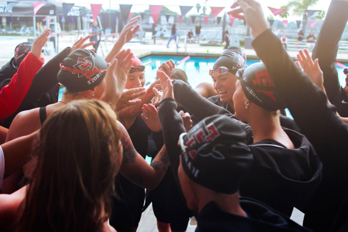 The Aztecs huddle together for one last pre-meet hype up – all hands in.