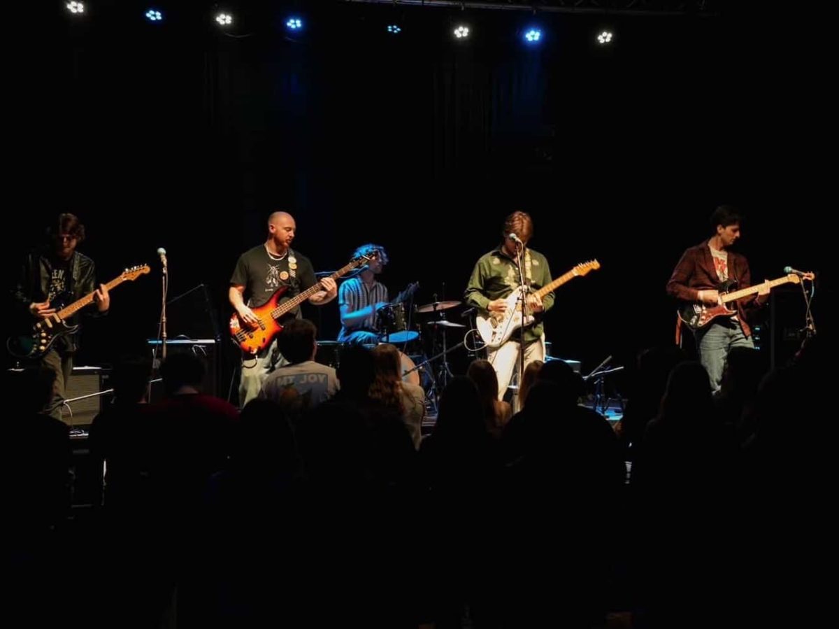 The members of Kickback perform at a live concert (Photo courtesy of J. Riley @navapache_photography)
