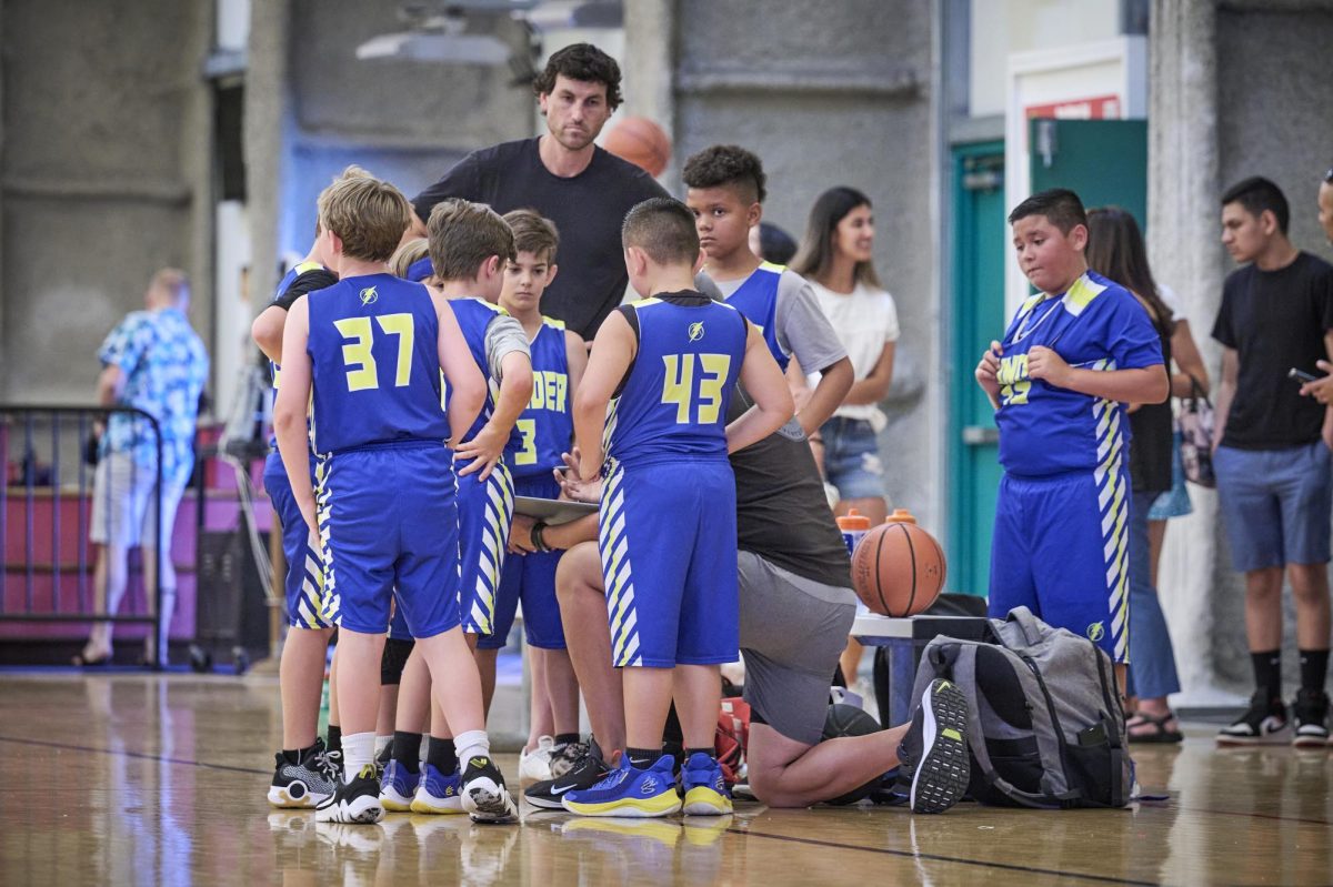 Youth boys basketball players huddle together during a game. Image courtesy of San Marcos basketball