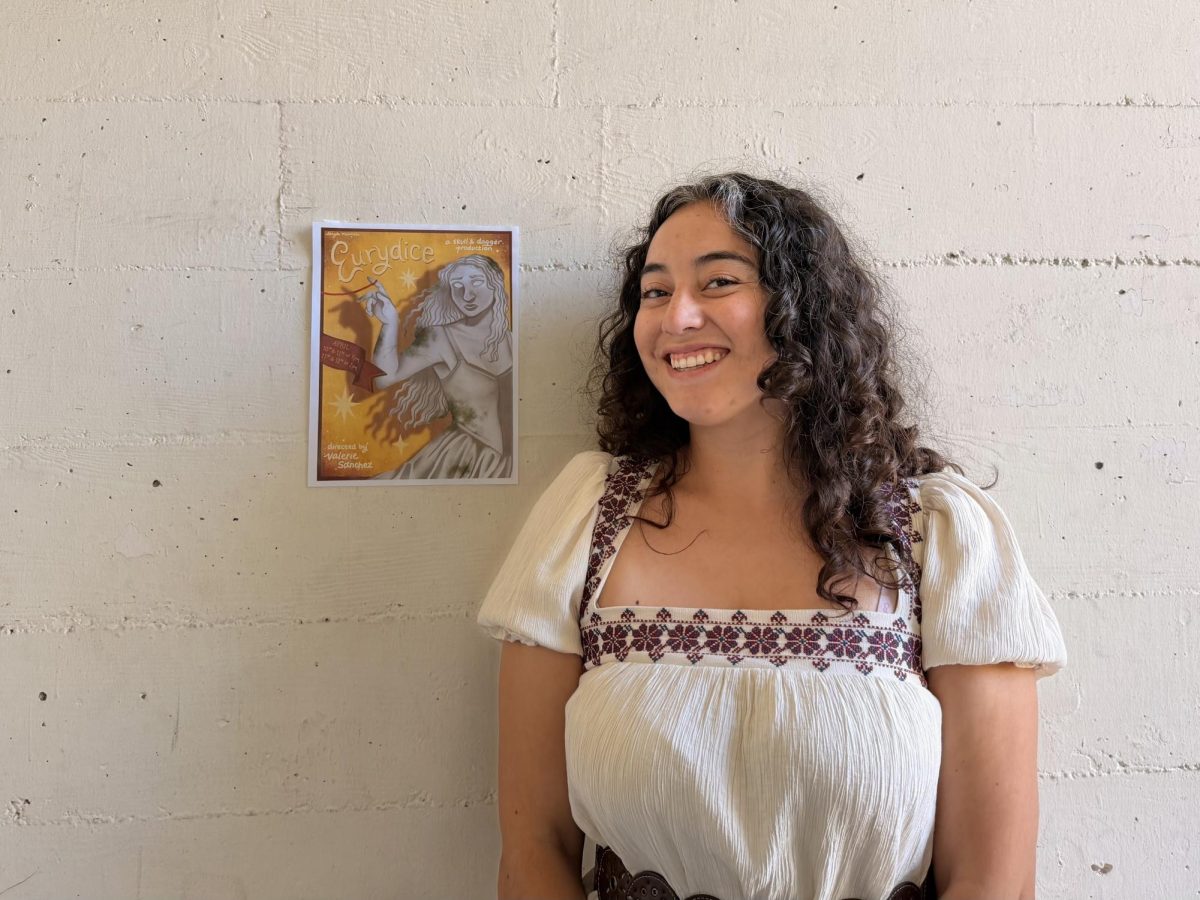 Director Valerie Sanchez poses next to Skull and Dagger's "Eurydice" poster outside the Experimental Theatre