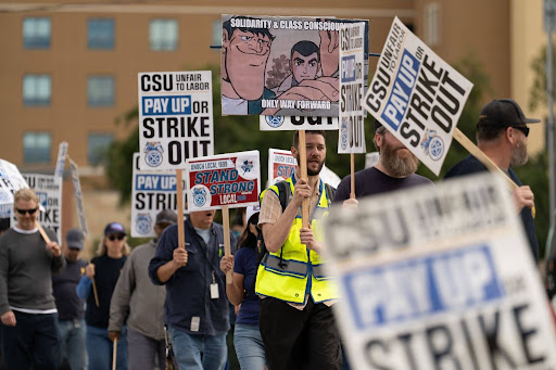 Teamsters Local 2010 members march along the sidewalk next to Hardy Avenue on San Diego State University's campus, Tuesday, Feb. 17, San Diego.