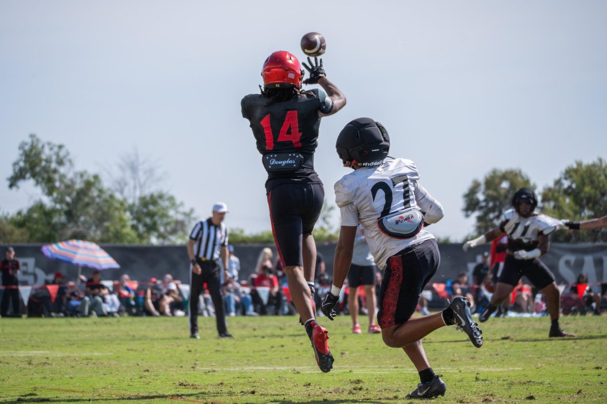 Wide receiver Donovan Brown (14) jumps for the ball against cornerback Mike Lindsay (27) at the Aztec spring game Tuesday, May 2, 2026, at San Diego state university 